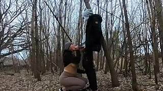 A woman with big breast exposes herself in a park and gives a blow job to a man