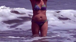 Mature blonde Latina flaunts her big assets by the sea