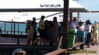 Kumalott - brunett nyter intens scene på båt med venner.