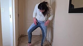 desperate amateur pissing in tight jeans and cozy fleece jacket.
