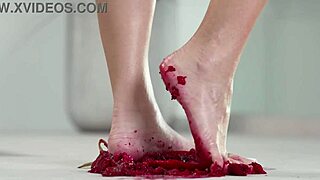 petite brunette crushes fruits with bare feet in heels