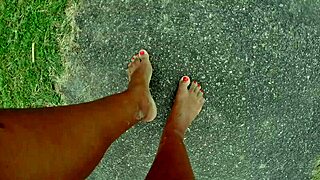 African pornstar walks barefoot on public beach, dirtying feet in fetish fun.