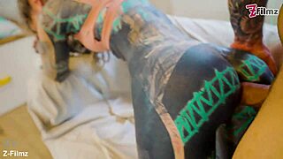 tattooed performer stretches and finishes with a gaping pose in goth style