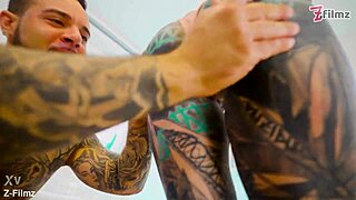 tattooed performer stretches and finishes with a gaping pose in goth style