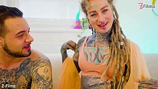 tattooed performer stretches and finishes with a gaping pose in goth style