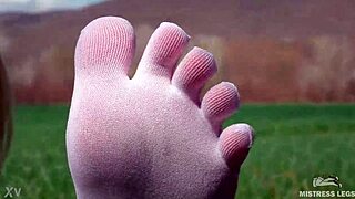Goddess spreads curly feet in white socks on spring grass field