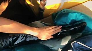 Woman in wetlook suit and patent leather boots licks ass