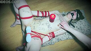 Bound slave gags on vibrator as candlestick