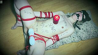 Bound slave gags on vibrator as candlestick