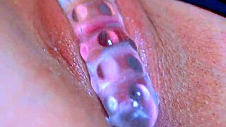 Girls' puffy shaved pussy gets wet with glass dildo in sensual amateur play