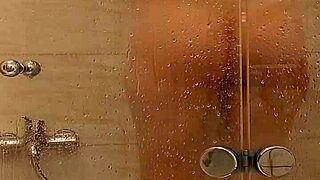 In the steamy bath, a voluptuous milf tenderly caresses her ample tits and juicy pussy.