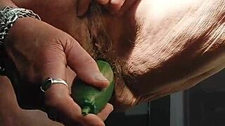 granny stuffs cucumber deep in her hairy wet pussy