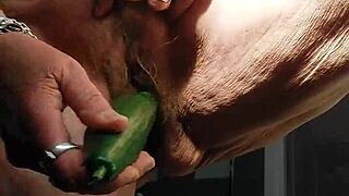 granny stuffs cucumber deep in her hairy wet pussy