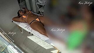 tanned beauty flashes big pussy during micro bikini massage