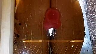 girl plays with toy in shower showing juicy ass