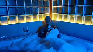 Tanned stud strokes huge cock in bubbly bath tub