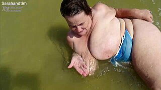 Granny's saggy huge tits and trimmed pussy tease closeup on windy beach with toes play