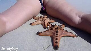 guy controls her remote vibrator while she walks nude on crowded beach