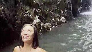 monika fox parades pink top yellow shorts through steamy jungle waterfalls