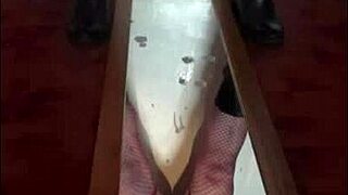 Bisexual crossdresser stands over mirror and releases